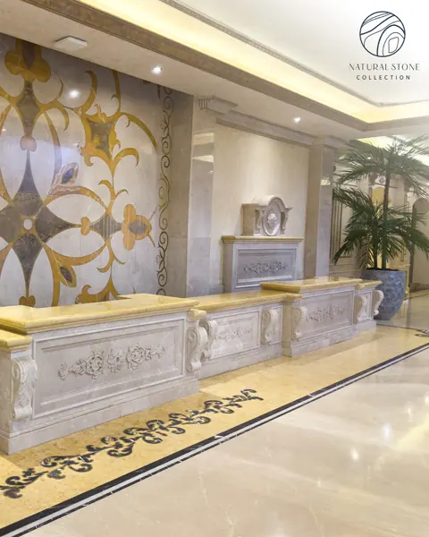 Soft cream stone is used for the bathroom walls and floor, alongside ornate mirrors and traditional decorative details.
