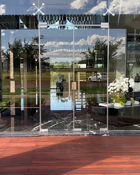 Stone with mirrored veining is used for the feature wall, alongside wide glazing and an open connection between spaces.