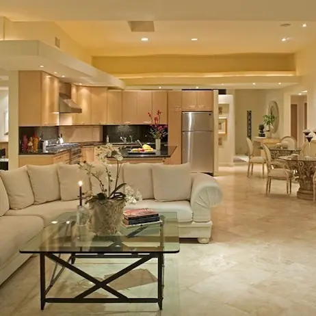 Soft cream stone is used for the floor throughout the room, alongside comfortable seating and a restrained neutral palette.