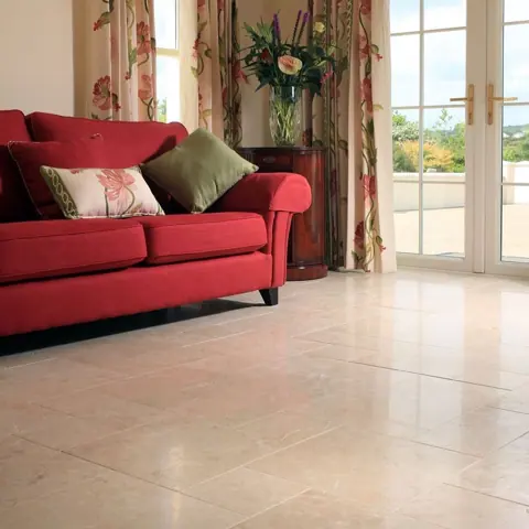 Pale veined stone is used for the floor throughout the room, alongside colourful furnishings and an expressive interior scheme.