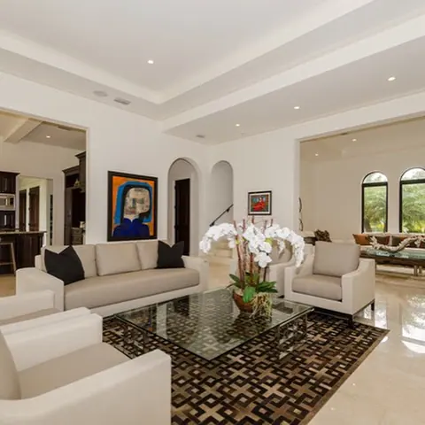 Soft cream stone is used for the floor throughout the room, alongside classical mouldings and decorative lighting.