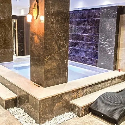 Rich brown veined stone is used for the feature wall, alongside a textured backdrop and subtle surface variation.
